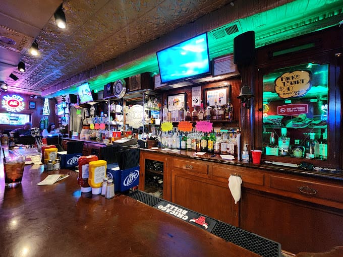 A bar with several tvs on the wall.